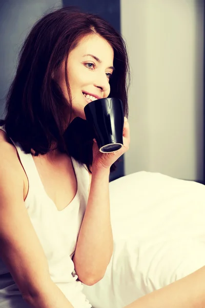 Mulher bebendo café na cama. — Fotografia de Stock