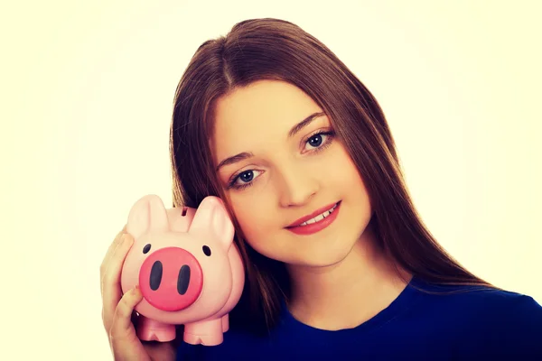 Tonåriga kvinna anläggning piggybank. — Stockfoto