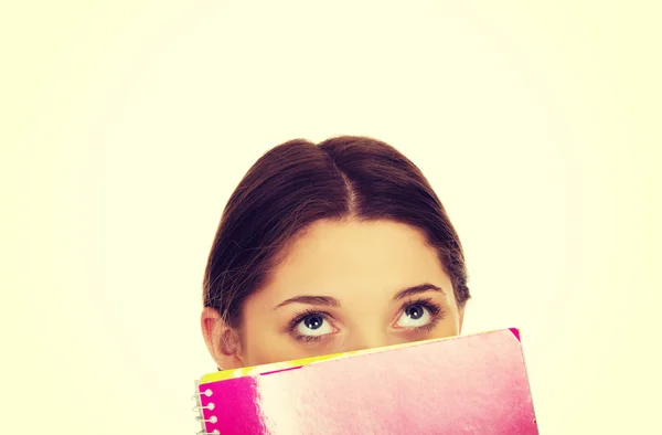 Έφηβος γυναίκα που κρύβεται πίσω από ένα σημειωματάριο. — Φωτογραφία Αρχείου