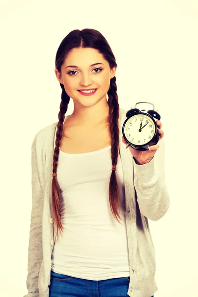 Happy teenage woman with alarmclock. — Stock Photo, Image