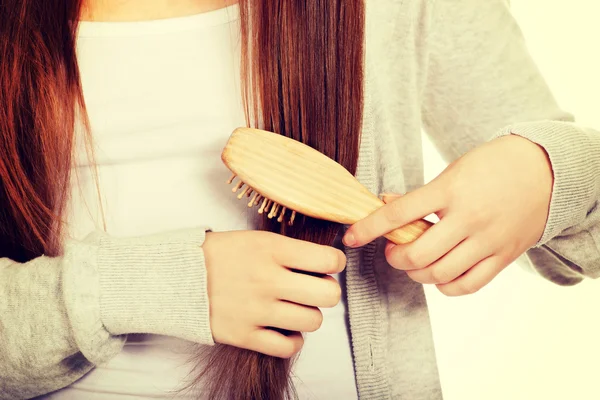 Mulher adolescente escovando o cabelo . — Fotografia de Stock