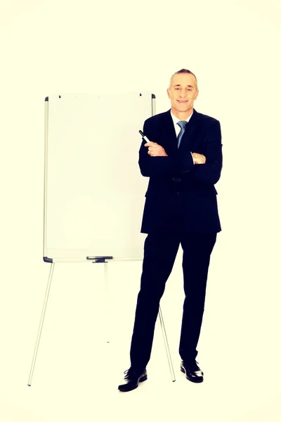 Uomo esecutivo in piedi vicino a flip chart — Foto Stock