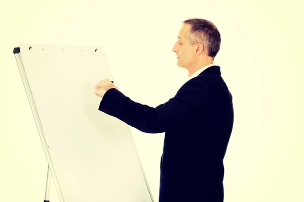 Escrita executiva masculina em um flipchart — Fotografia de Stock