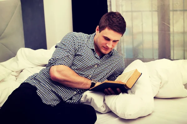 Hombre leyendo un libro en su cama . —  Fotos de Stock