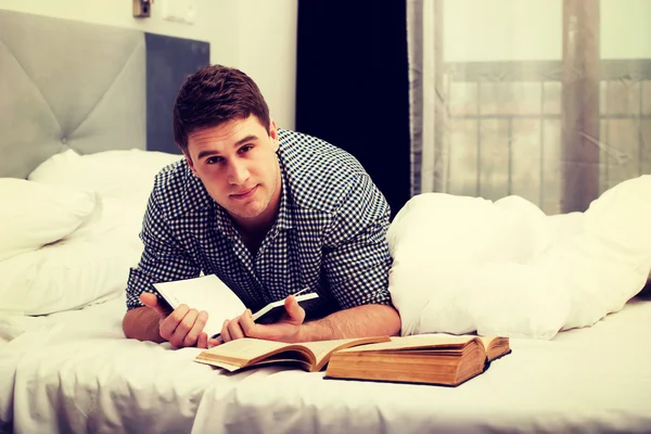 Un hombre reflexivo con un libro en su cama . —  Fotos de Stock
