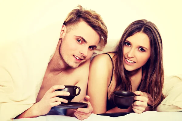 Casal feliz beber café na cama . — Fotografia de Stock