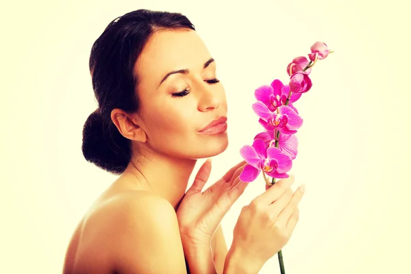 Donna in topless con ramo di orchidea viola — Foto Stock