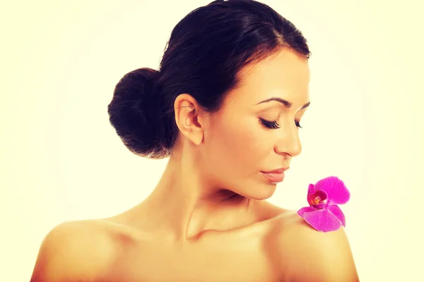 Woman with purple orchid petal on shoulder — Stock Photo, Image