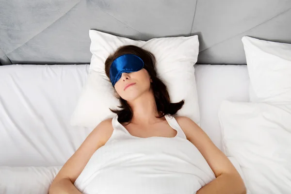 Woman sleeping in bed with eyes band. — Stock Photo, Image