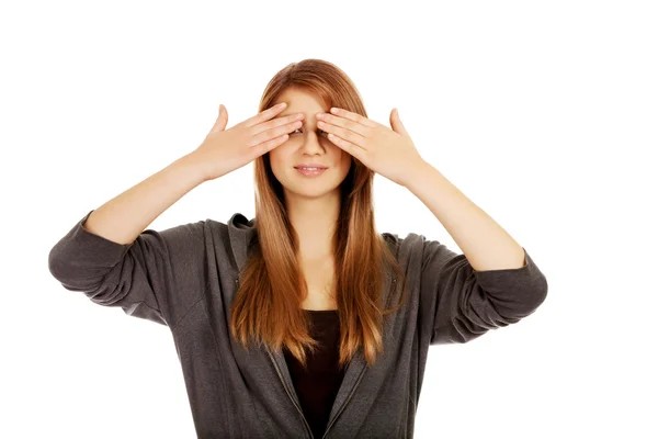 Teenage vrouw die betrekking hebben op haar ogen met beide handen — Stockfoto