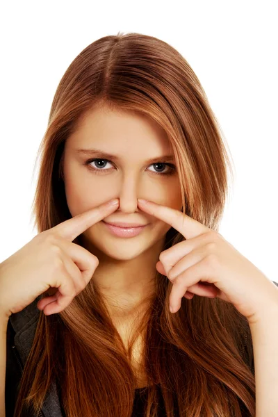 Young woman pinches nose with fingers hands looks — Stock Photo, Image