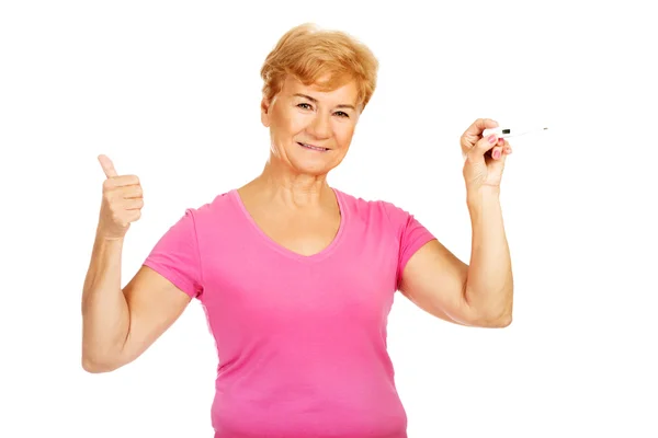 Senior woman shows thermometer and gesturing OK — Stock Photo, Image