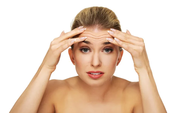 A young woman checking wrinkles on her forehead — Stock Photo, Image