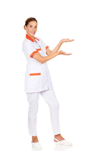 Улыбающаяся женщина-врач или медсестра указывает на что-то — стоковое фото