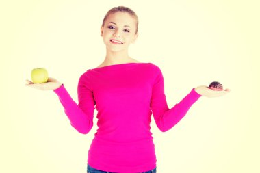 bir elma ve çerez tutan genç casual kadın.