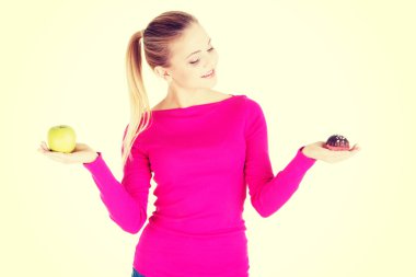 bir elma ve çerez tutan genç casual kadın.