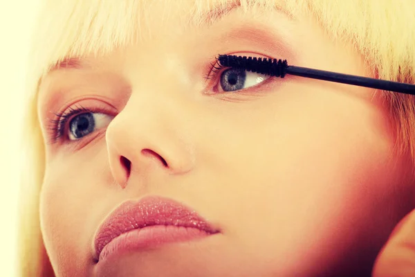 Close up on beautiful young woman doing make up on eyelashes. — Stock Photo, Image