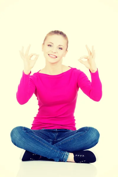 Young casual woman student showin OK gesture. — Stock Photo, Image