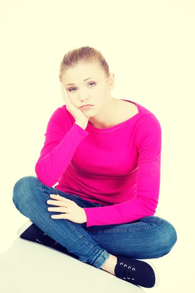 Young sad woman sitting. — Stock Photo, Image