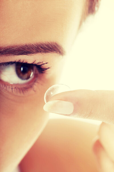 Woman putting contact lens in her eye