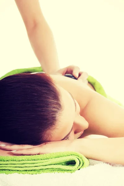 Mooie vrouw op spa salon met stenen massage. — Stockfoto