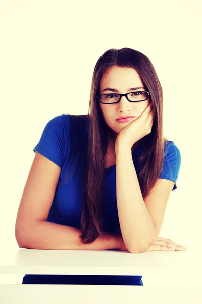 Young student woman bored, sitting by the desk. — Stock Photo, Image