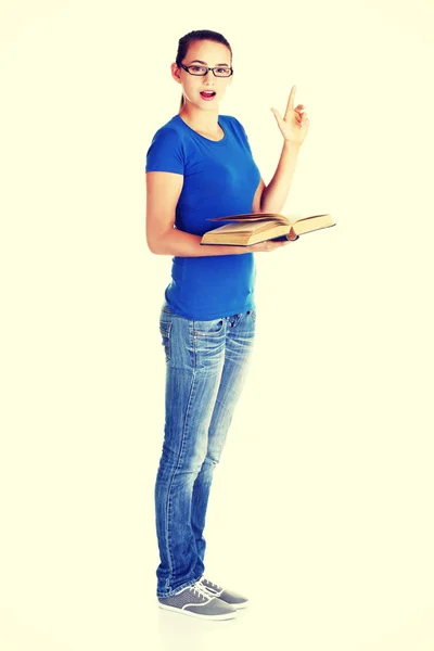 Young casual student woman with book and pointing up. — Stock Photo, Image