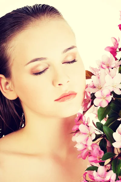 Donna con pelle sana e pulita e fiori rosa — Foto Stock