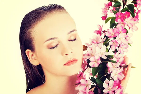 Mujer con piel sana y limpia y flores rosadas —  Fotos de Stock