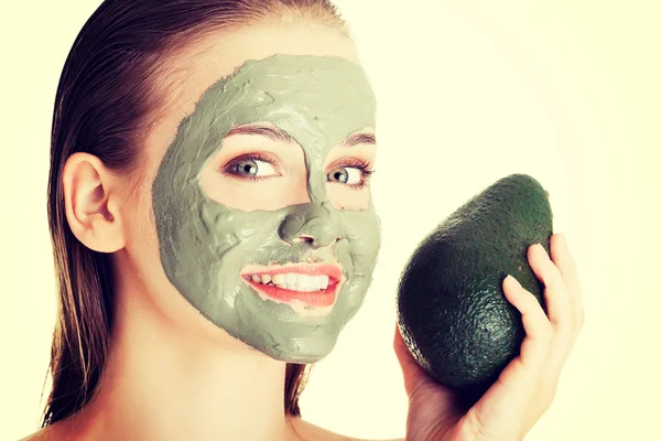 Spa vrouw in gezichtsmasker en avocado — Stockfoto