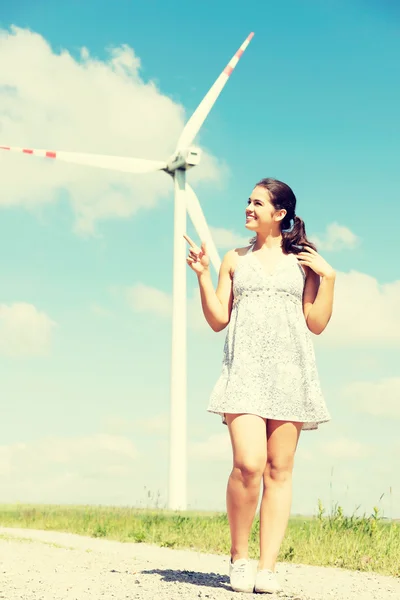 Gelukkig tiener meisje naast je eigen windturbine. — Stockfoto