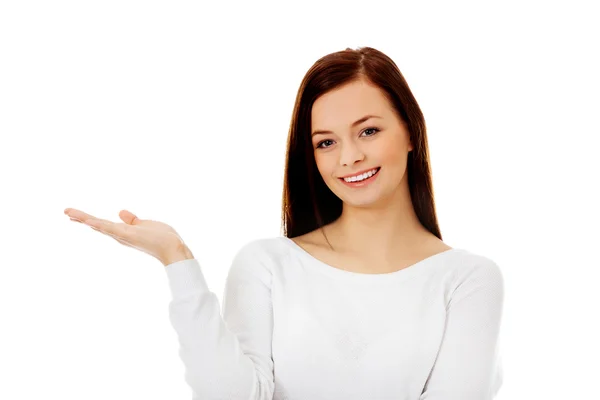 Mujer joven sonriente presentando algo en la palma abierta —  Fotos de Stock