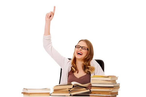 Mujer joven con libros apilados apuntando hacia arriba —  Fotos de Stock