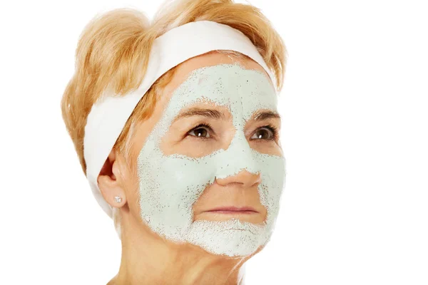 Avslappnad äldre kvinna i ansiktsmask — Stockfoto