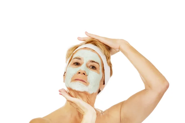 Relaxed elderly woman in facial mask — Stock Photo, Image