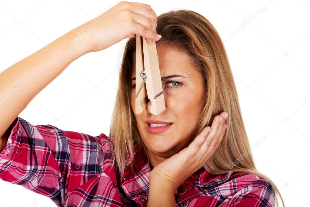 Young woman pinching her nose with a huge clothespin — Stock Photo