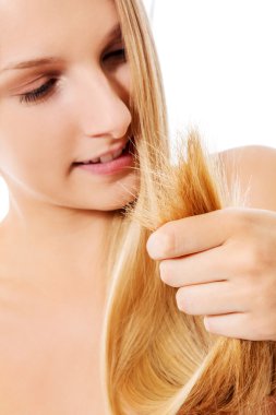 Güzel bir kadın sağlıklı saçlarını tutuyor.