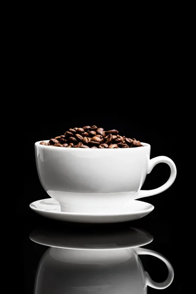 Tazza bianca con semi di caffè su sfondo nero — Foto Stock