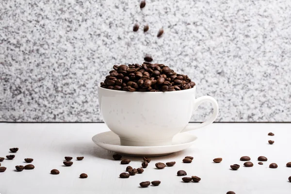 Tasse blanche avec des graines de café sur fond de granit — Photo