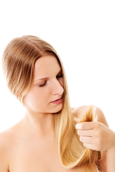 Šokovaná žena ukazující její poškozené split končí vlasů. — Stock fotografie