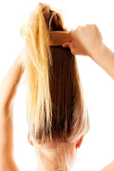 Chica con el pelo largo y liso peinándose. —  Fotos de Stock