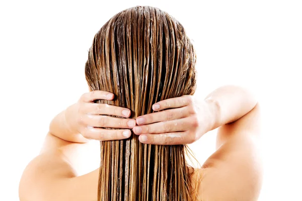 Vrouw die haar conditioner aanbrengt. geïsoleerd op wit. — Stockfoto