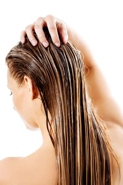 Woman applying hair conditioner. Isolated on white. — Stock Photo, Image