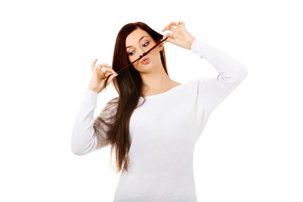 Zabawna studentka układająca włosy jak wąsy — Zdjęcie stockowe