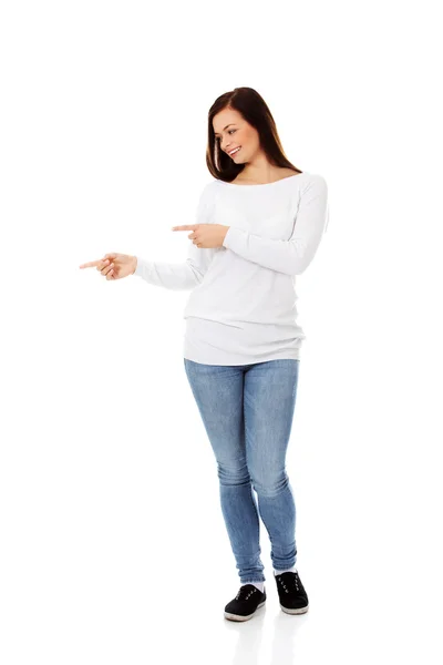 Smiling young woman shows something — Stock Photo, Image