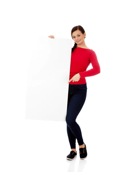 Beautiful student woman pointing on blank board — Stock Photo, Image