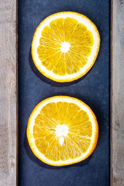 Two juicy slices on black board — Stock Photo, Image