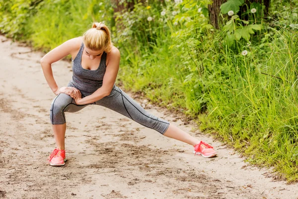 Ung idrottskvinna stretcha och förbereda sig för att köra. — Stockfoto