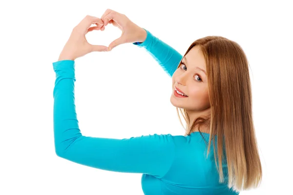 Smiling teenage woman making heart shape — Stock Photo, Image