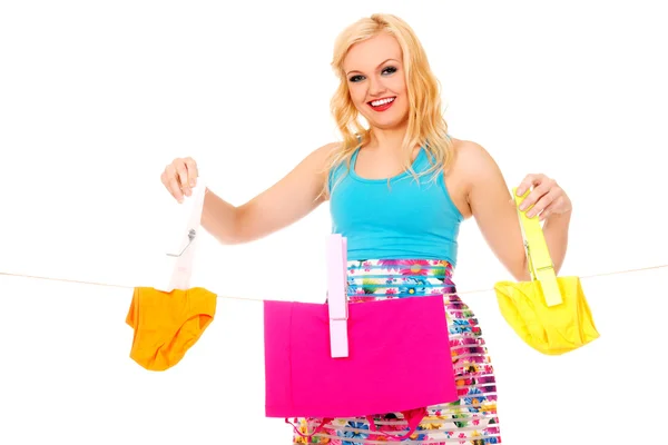 Junge Frau hängt Wäsche mit riesiger Wäscheklammer auf — Stockfoto